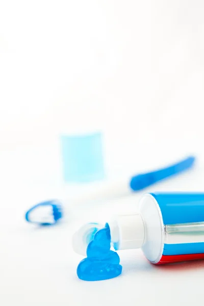 Blauwe tandenborstel naast een tube tandpasta — Stockfoto