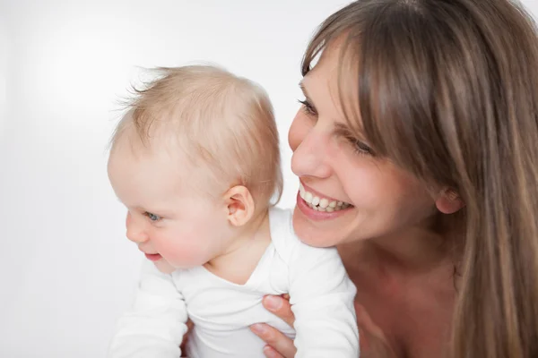 Mujer riendo sosteniendo a su linda hija Imágenes De Stock Sin Royalties Gratis