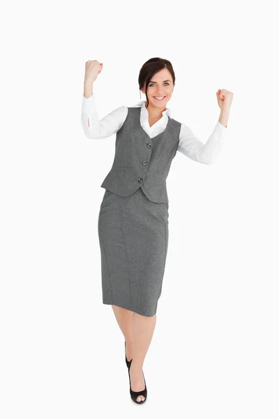 Woman in grey suit walking the fists raised Stock Photo