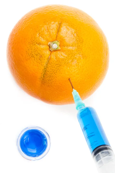 Syringe injecteren blauwe vloeistof in een oranje — Stockfoto