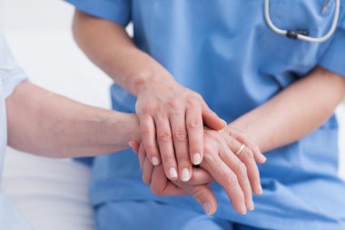 Close up of a nurse touching hand of a patient clipart
