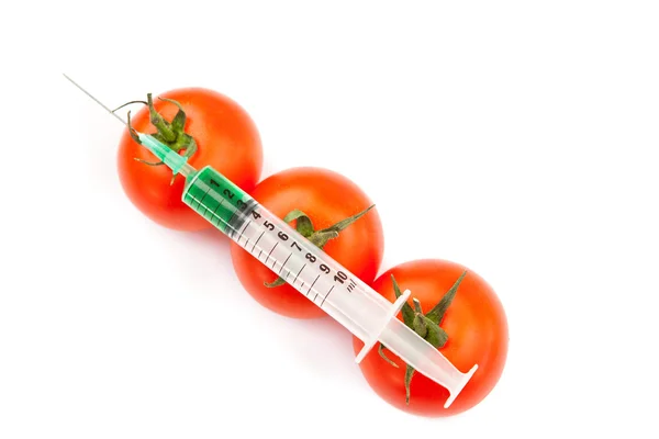 Syringe on tomatoes — Stock Photo, Image