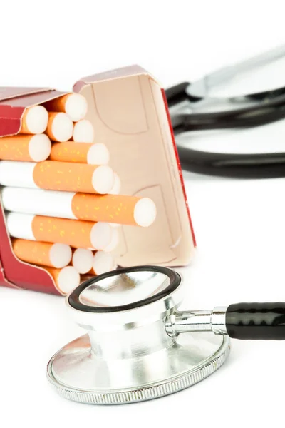 Pacchetto di sigarette accanto a uno stetoscopio — Foto Stock