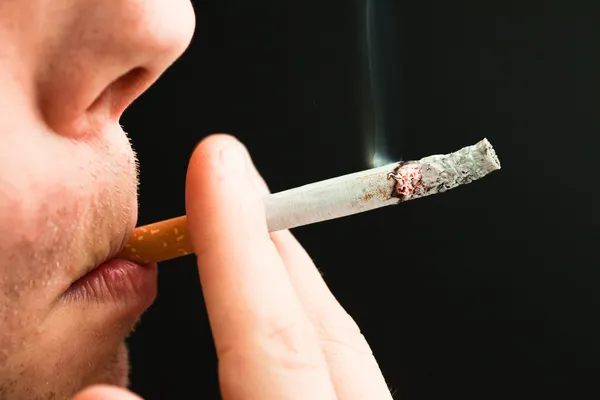 Een man die een sigaret rookt — Stockfoto