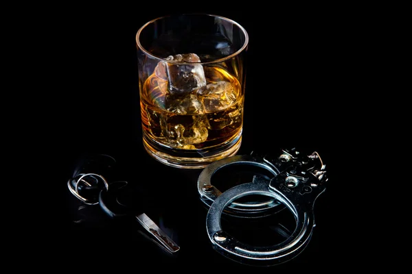 Whisky op de rotsen met handboei en auto sleutel — Stockfoto