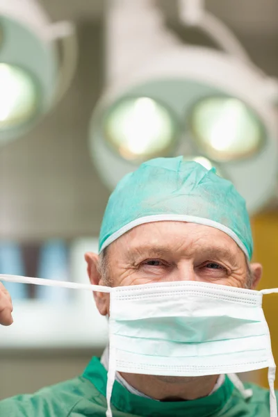 Közelkép a sebész felhúzása sebészeti maszk — Stock Fotó
