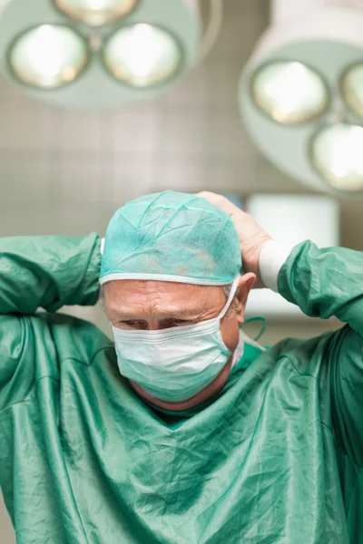 Surgeon putting on a face mask on his head — Stock Photo, Image