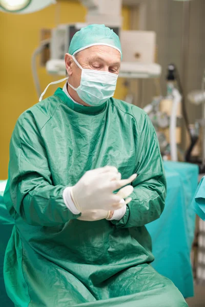 Cirurgião colocando luvas cirúrgicas — Fotografia de Stock