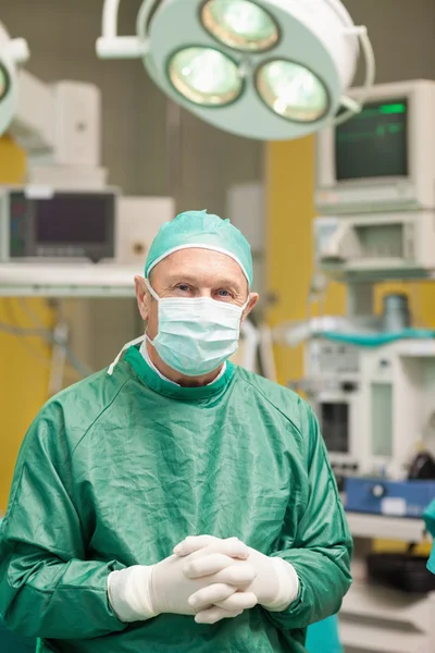 Chirurg uśmiechający się podczas przekraczania jego ręce — Zdjęcie stockowe