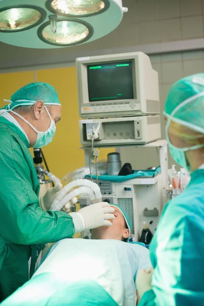 Chirurg setzt einer Patientin eine Sauerstoffmaske auf — Stockfoto