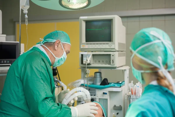 Cirujano sosteniendo una máscara en la cara de un paciente — Foto de Stock