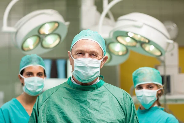 Surgeon posing with two women behind him — Stock Photo, Image