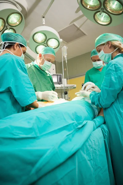 Equipe médica operando um paciente — Fotografia de Stock