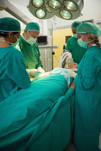 Paciente sendo operado por uma equipe de cirurgiões — Fotografia de Stock