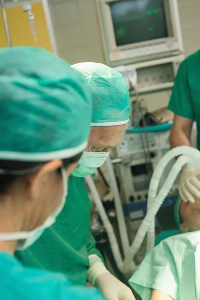 Chirurgien et une équipe opérant un patient endormi — Photo
