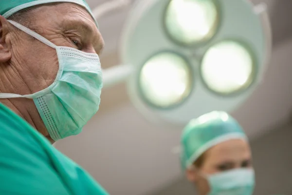 Два хирурга стоят под хирургическим светом — стоковое фото