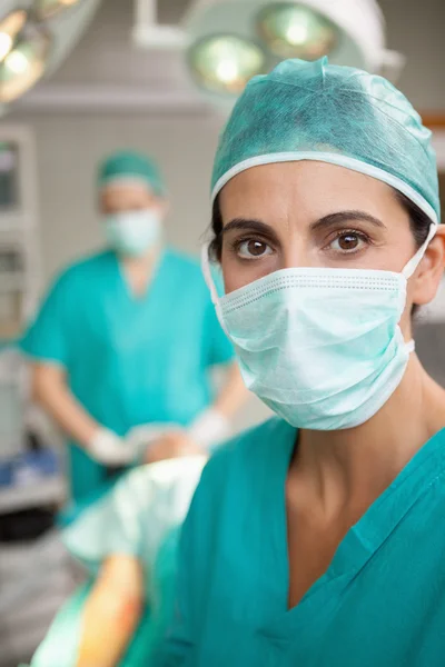 Serious surgeon standing in front of a colleague — Stock Photo, Image