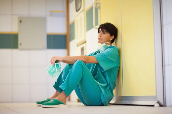 Tänkande kirurg sitter på golvet — Stockfoto