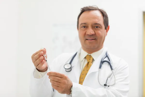 Lächelnder Arzt bereitet eine Spritze vor — Stockfoto