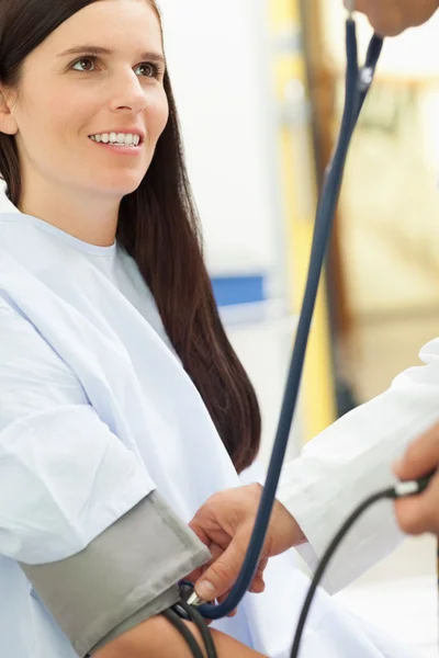 Lachende patiënt kijken naar een arts terwijl hij zijn het nemen van haar bloo — Stockfoto