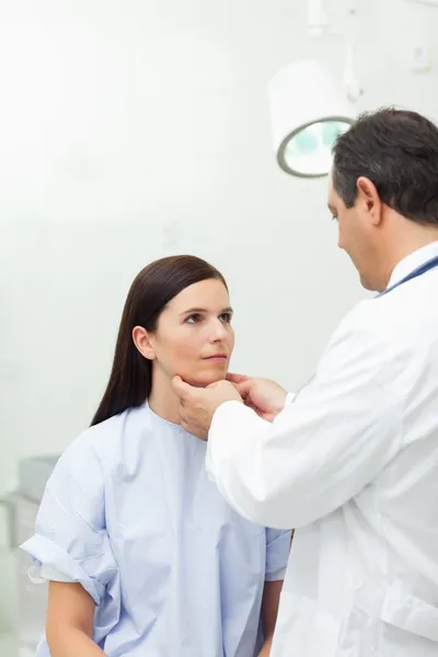 Doktor dotýká krku pacienta — Stock fotografie