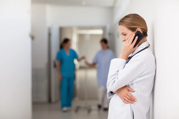 Femme médecin téléphone dans le couloir — Photo