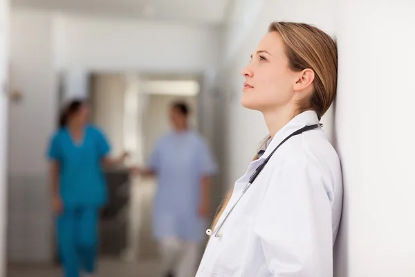 Thoughtful doctor against a wall — Stock Photo, Image