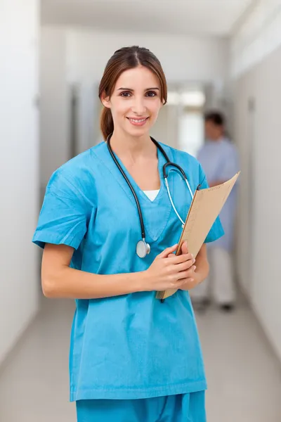 Smiling nurse holding a file while standing — Stock Photo, Image