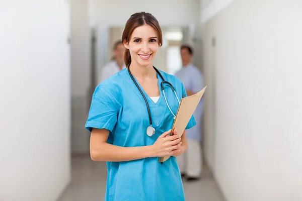 Nurse smiling while holding a file — Stock Photo, Image