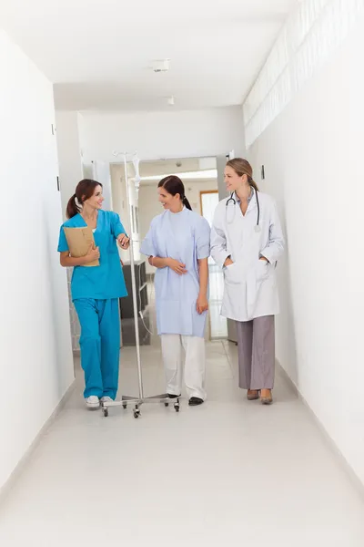 Läkare gå med en patient och sjuksköterska — Stockfoto