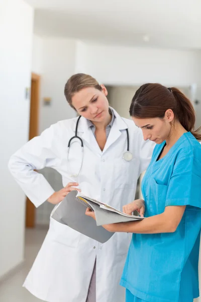 Nurse and a doctor looking in a file — Stock Photo, Image