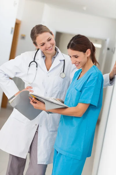 Uśmiechnięte pielęgniarki i lekarza, patrząc w pliku — Zdjęcie stockowe