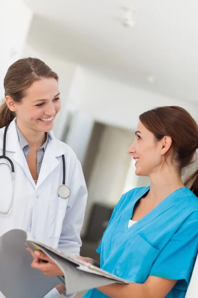 Doctor and nurse smiling while looking at each other — Stock Photo, Image