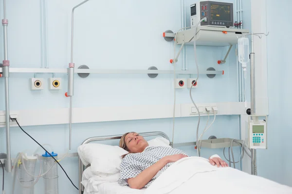 Paciente feminina deitada em uma cama — Fotografia de Stock
