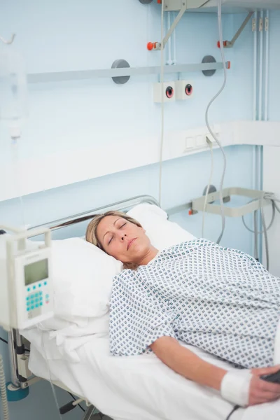 Female patient lying on a medical bed with closed eyes — Stock Photo, Image