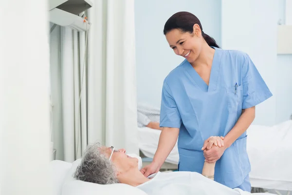 Enfermera sosteniendo la mano de un paciente — Foto de Stock