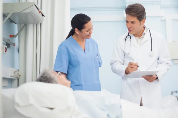 Médico e enfermeiro conversando com um paciente — Fotografia de Stock