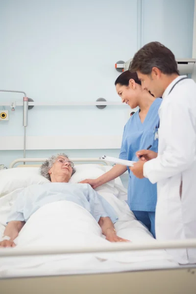 Médico y enfermera hablando con un paciente — Foto de Stock