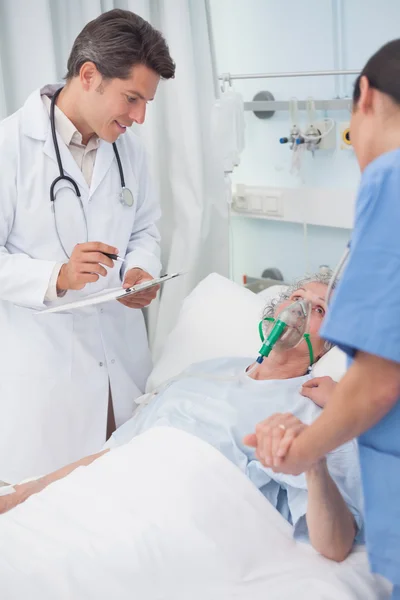 Médico mirando al paciente junto a una enfermera —  Fotos de Stock