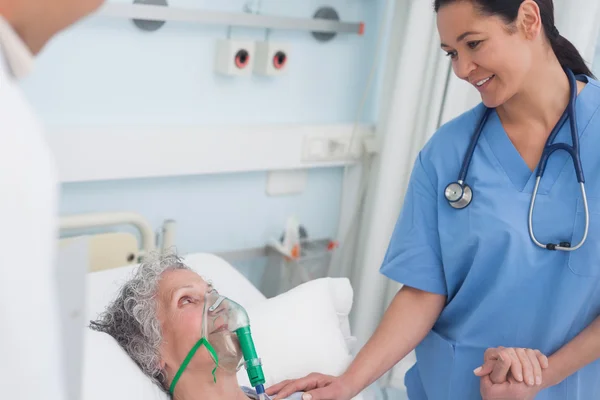 Krankenschwester berührt die Hand eines Patienten — Stockfoto