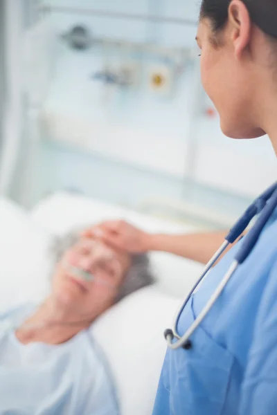 Nurse looking at a patient while touching her — Stock Photo, Image