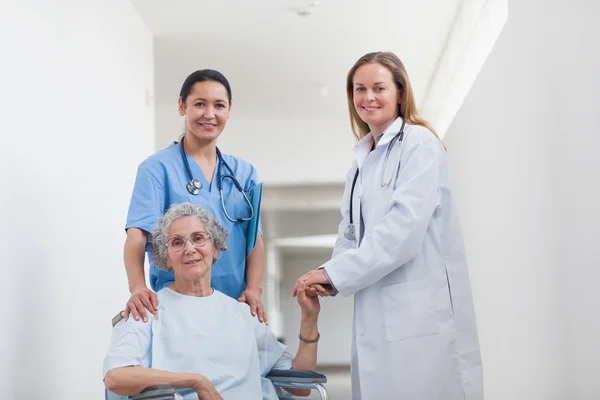 Patient in corridor holding hand of a doctor — Stock Photo, Image