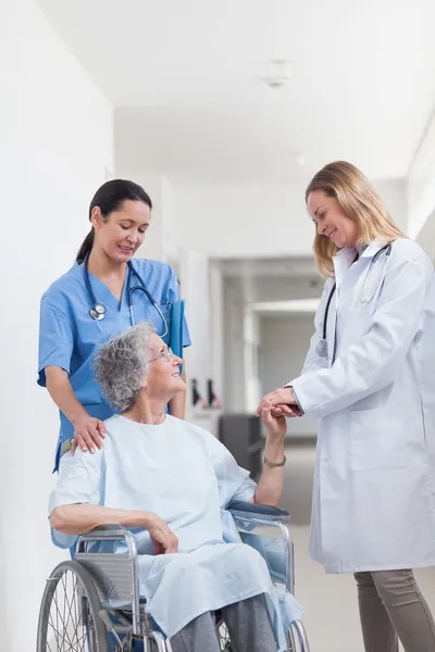 Arts kijken naar een patiënt op een rolstoel — Stockfoto