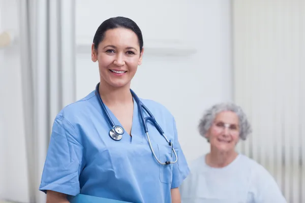 Sjuksköterskan och patienten tittar på kameran — Stockfoto