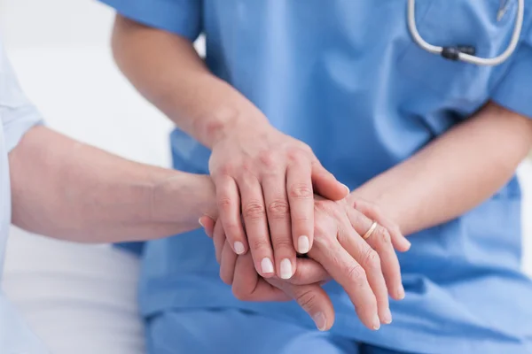 Close up van een verpleegster aanraken van de hand van een patiënt — Stockfoto