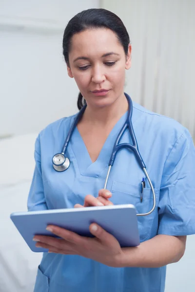 Медсестра трогает планшетный компьютер — стоковое фото