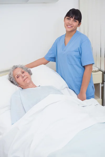 Νοσοκόμα που στέκεται δίπλα σε έναν ασθενή — Φωτογραφία Αρχείου