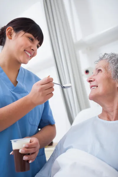 Sjuksköterska utfodring en patient — Stockfoto