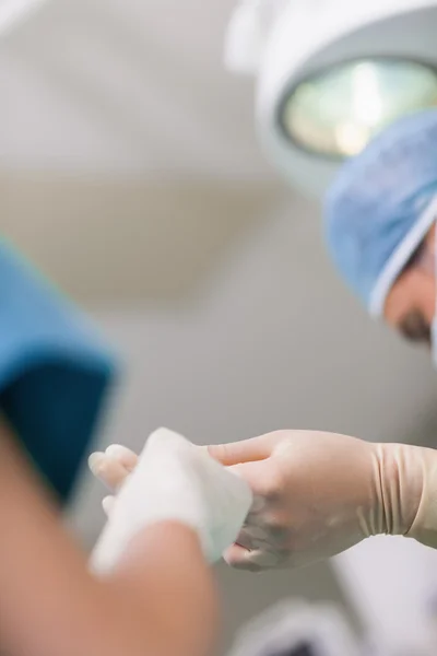 Close up de uma enfermeira dando uma tesoura cirúrgica para um médico — Fotografia de Stock