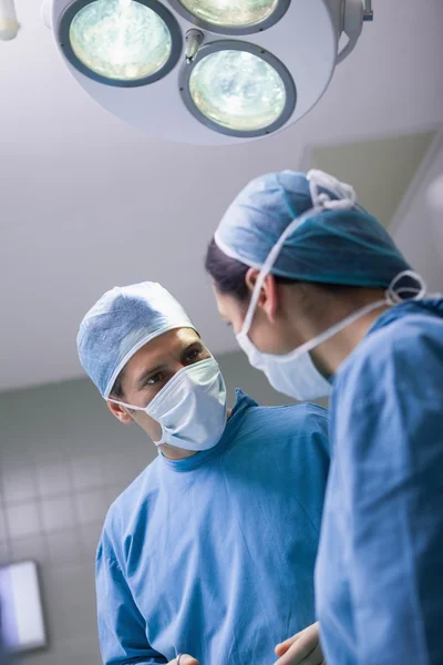 Serious doctor looking at a nurse — Stock Photo, Image